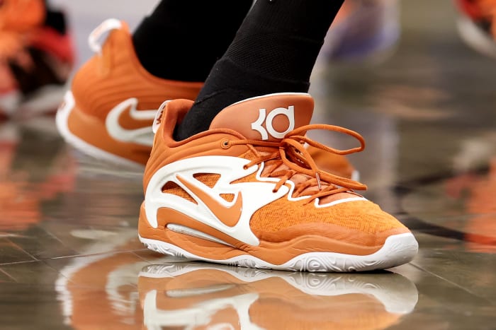 View of Kevin Durant's orange and white Nike shoes.